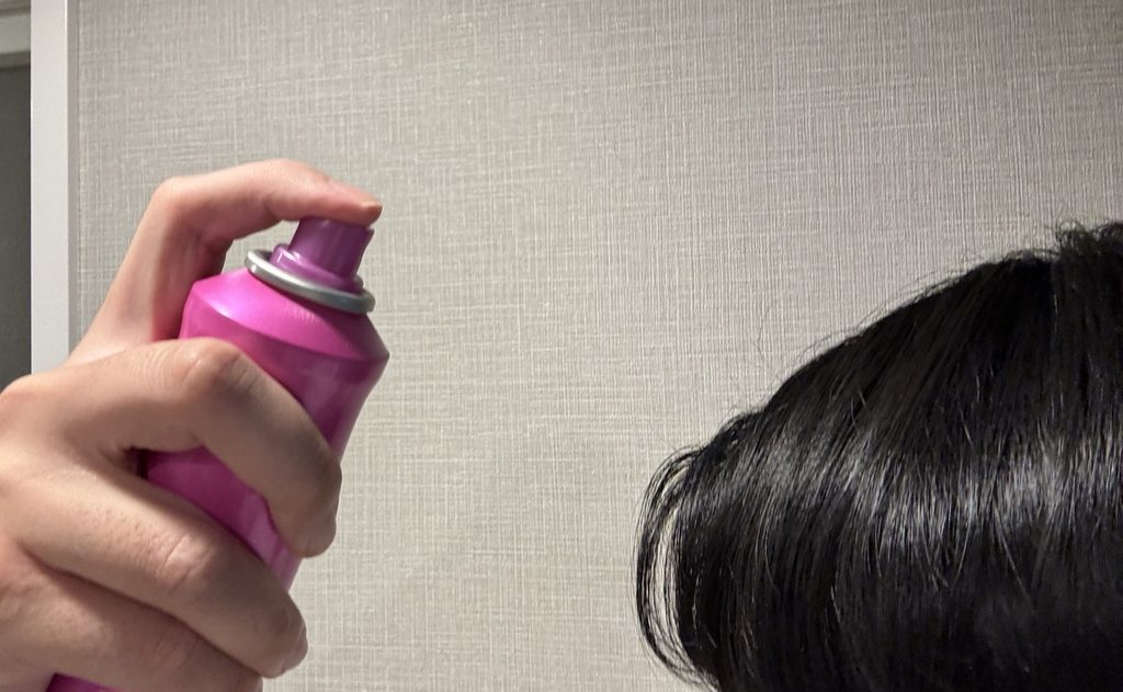 トリエ スプレー10を髪から離して使用する様子